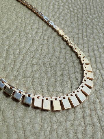 Vintage cleopatra 14k gold Necklace with square links on a textured surface