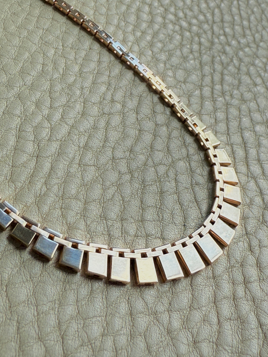 Vintage cleopatra 14k gold Necklace with square links on a textured surface