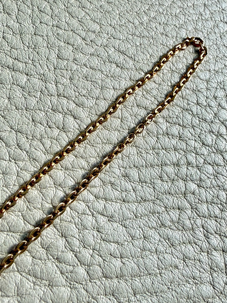 Gold chain on a light gray textured surface