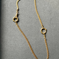 Gold chain necklace on a gray background