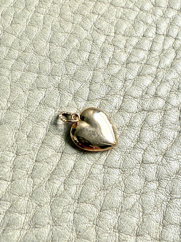 Gold heart-shaped pendant on a textured light gray background