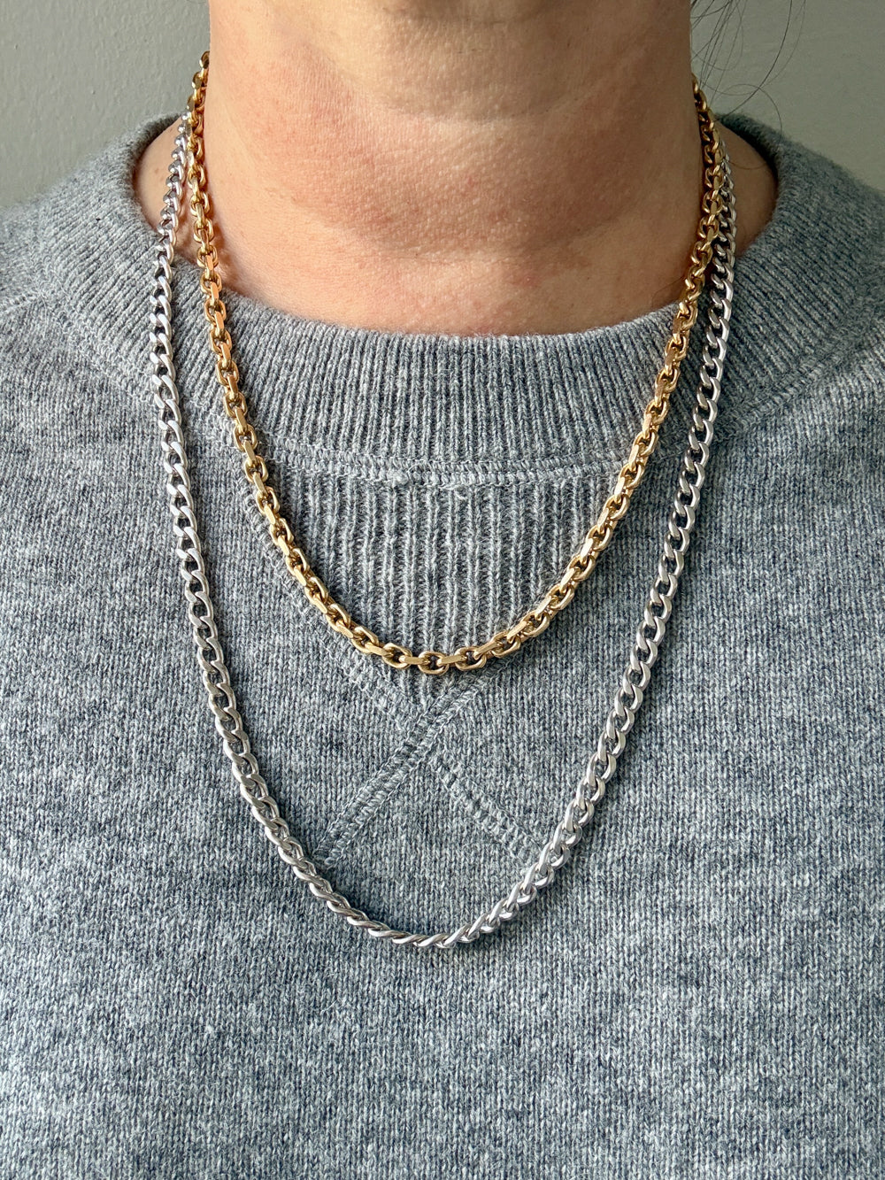 vintage gold necklaces on a person wearing a gray sweater