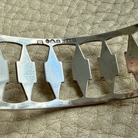 silver vintage bracelet detail with decorative elements on a textured beige surface