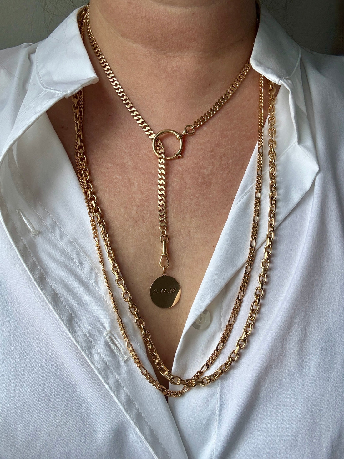 Gold chain necklaces on a white shirt