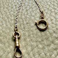 Close-up of a necklace with clasp on a textured surface