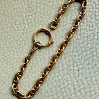 18k gold antique watch chain bracelet on a light green textured surface
