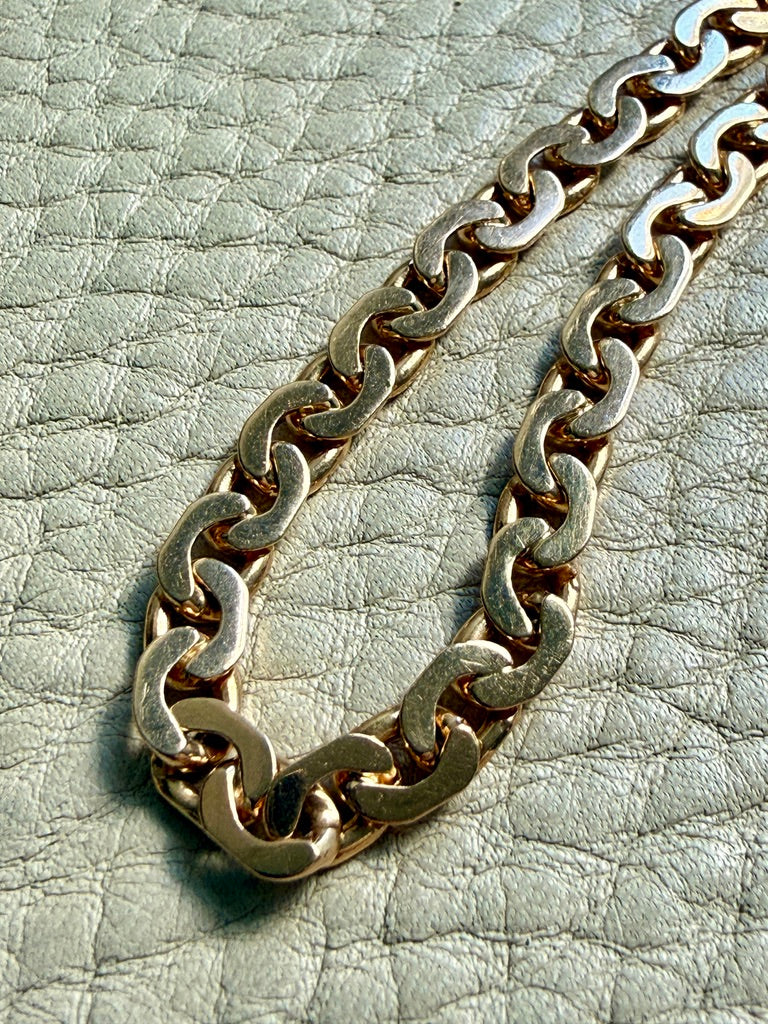 18k Gold virola chain on a textured light gray surface