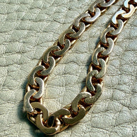 18k Gold virola chain on a textured light gray surface