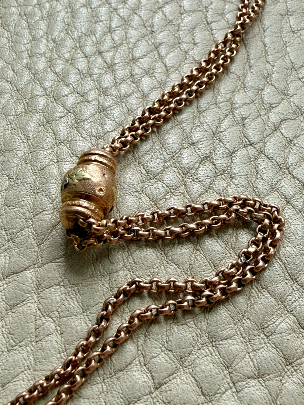 gold chain necklace on a textured light gray surface