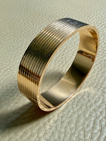 Gold bangle on a textured surface
