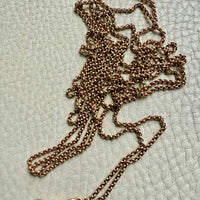 18k gold chain with clasp on a textured light green background Penelope Penelope vintage gold chains