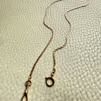 18k Gold virola link watch chain on a textured light gray surface