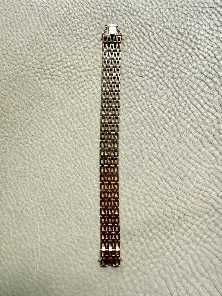 gold link bracelet on a textured light gray background