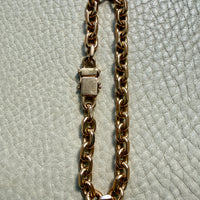 18k gold vintage biker link chain bracelet on gray textured surface penelopepenelope.com
