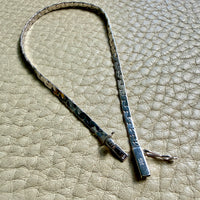 14k white gold bracelet on a textured beige surface