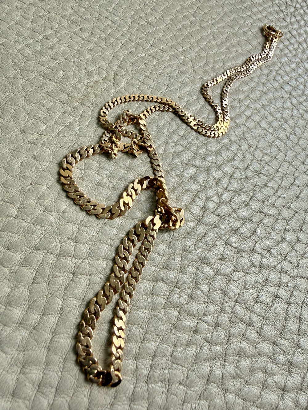 18k vintage Gold chain necklace on a textured light gray surface