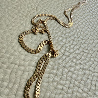 18k vintage Gold chain necklace on a textured light gray surface
