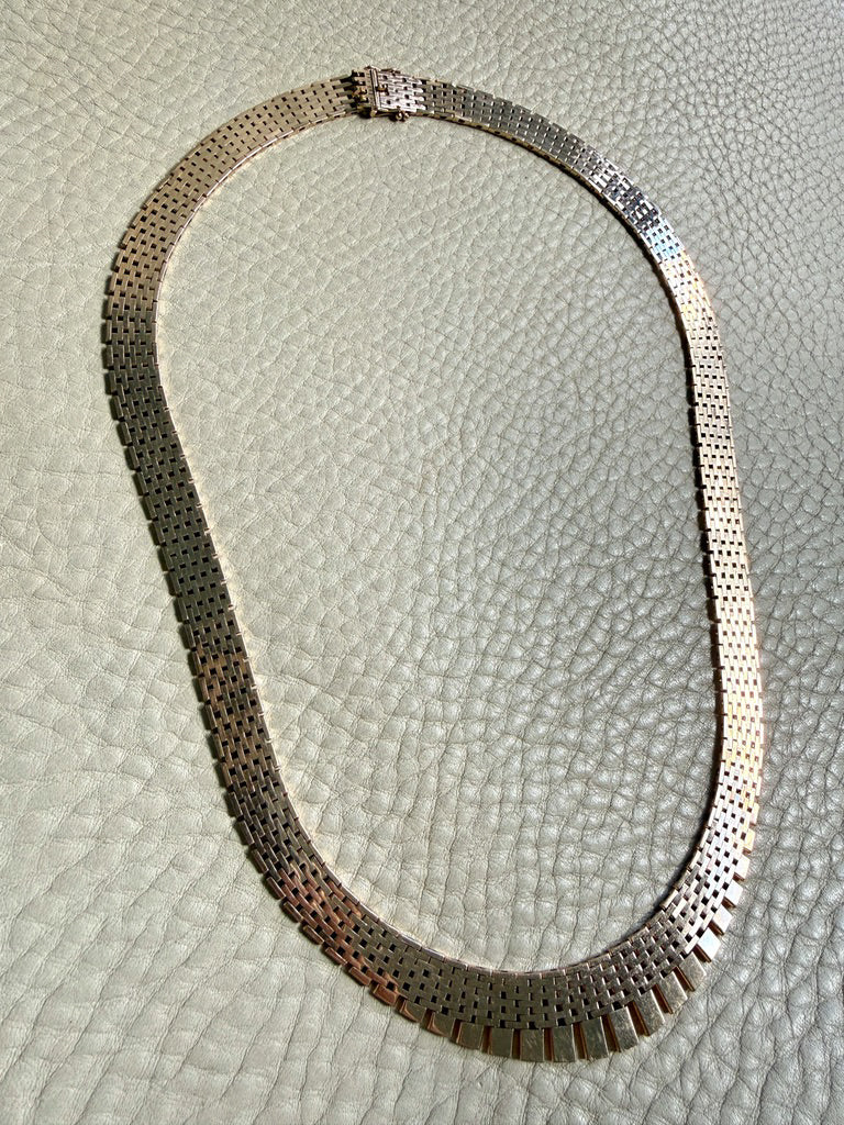 14k gold vintage cleopatra necklace on a textured light gray surface