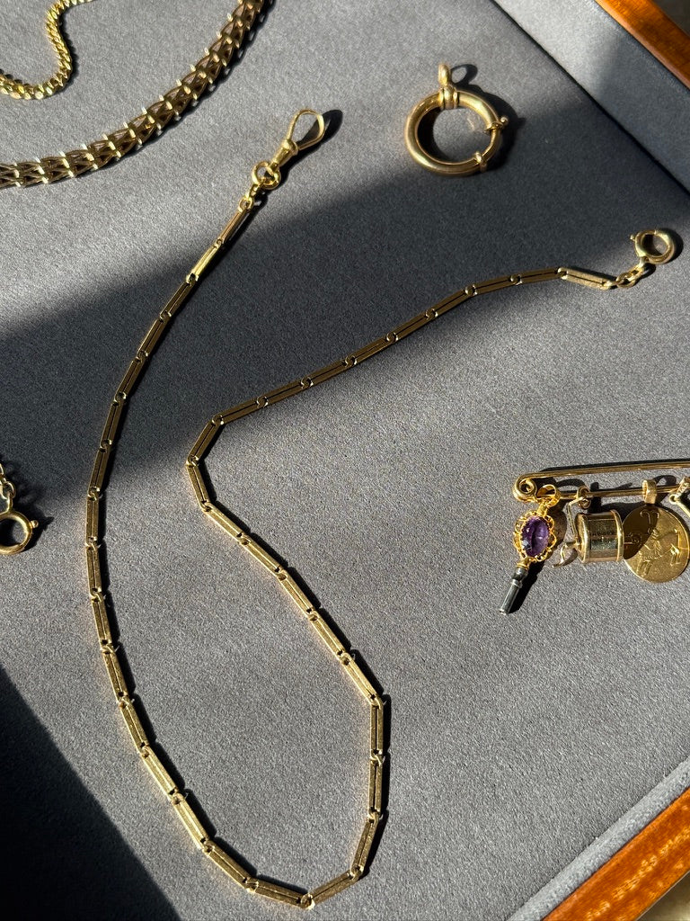 Gold necklace on a gray surface