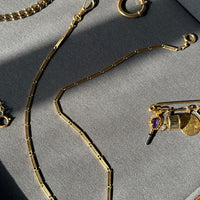 Gold necklace on a gray surface