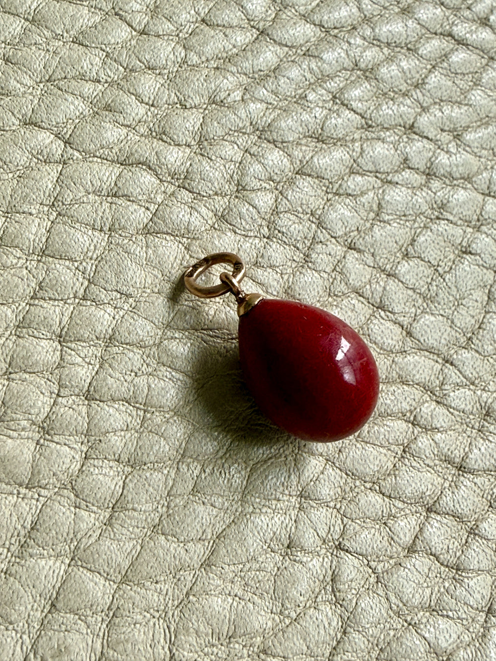 red purpurin egg pendant on gray background