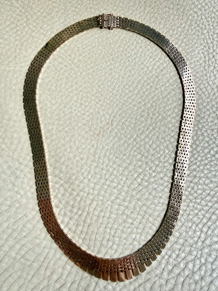 14k gold vintage cleopatra necklace on a textured light gray background