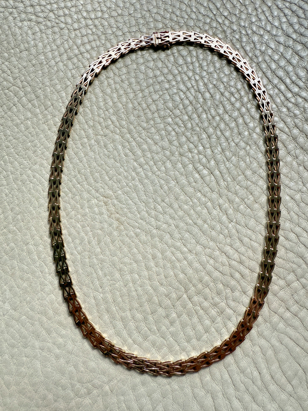 gold chain necklace on a textured gray surface