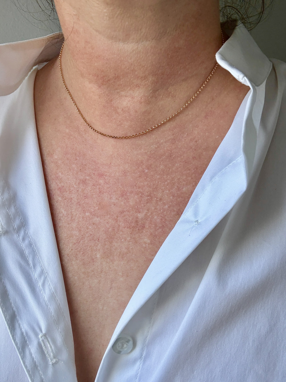 18k gold rolo Necklace on a person wearing a white shirt
