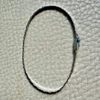 14k white gold bracelet on a textured beige surface