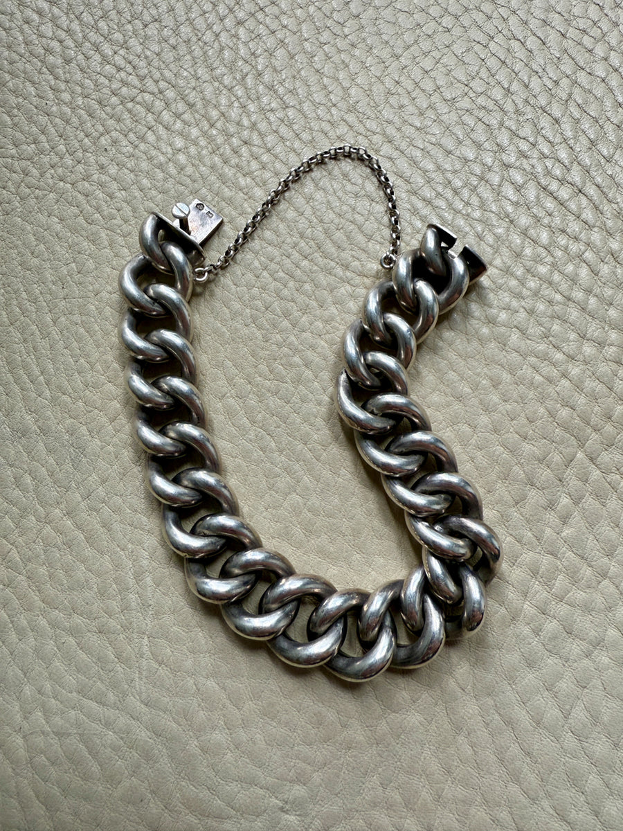Silver chain bracelet on a textured beige surface