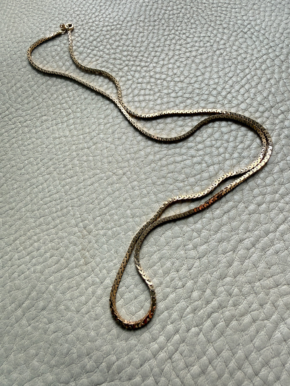 vintage 18k gold unique link  necklace on a textured gray surface