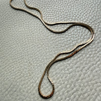 vintage 18k gold unique link  necklace on a textured gray surface