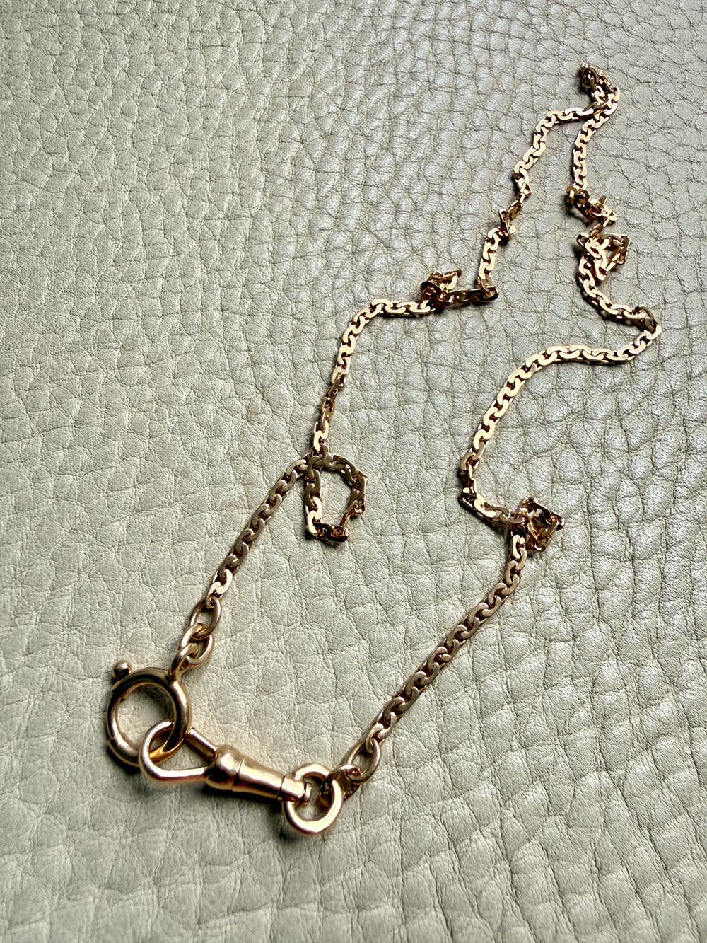 18k Gold virola link chain on a textured light gray surface