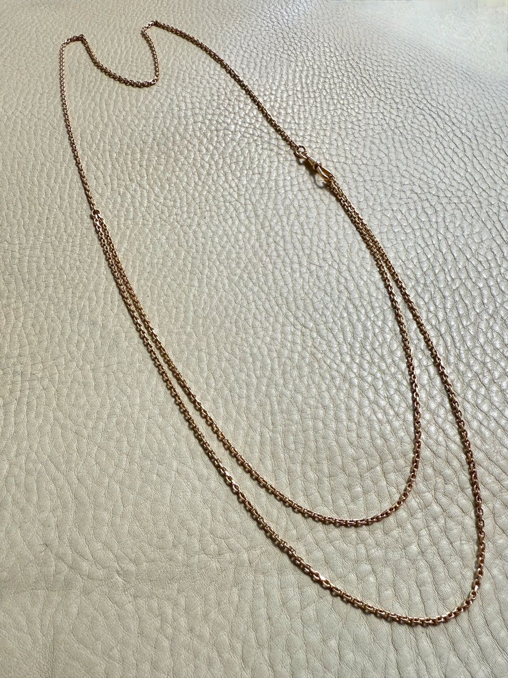 antique 18k gold chain necklace on a textured beige surface. Penelope Penelope vintage 18k gold fine jewelry