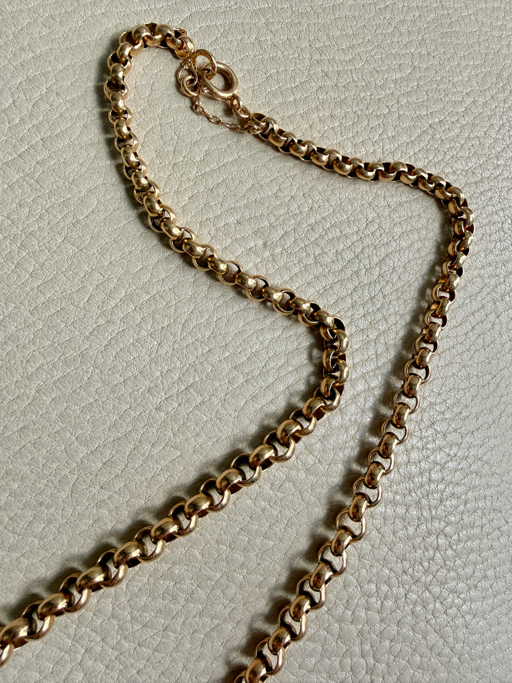 Gold chain vintage necklace on a textured light gray background
