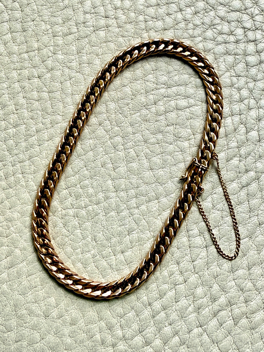 18k vintage Gold curb chain bracelet on a textured light gray surface 