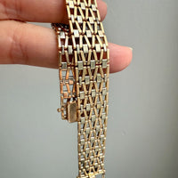 Gold bracelet held by a hand against a gray background. Penelope Penelope Vintage Gold Jewelry