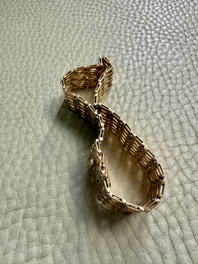 Gold bracelet on a textured light gray surface