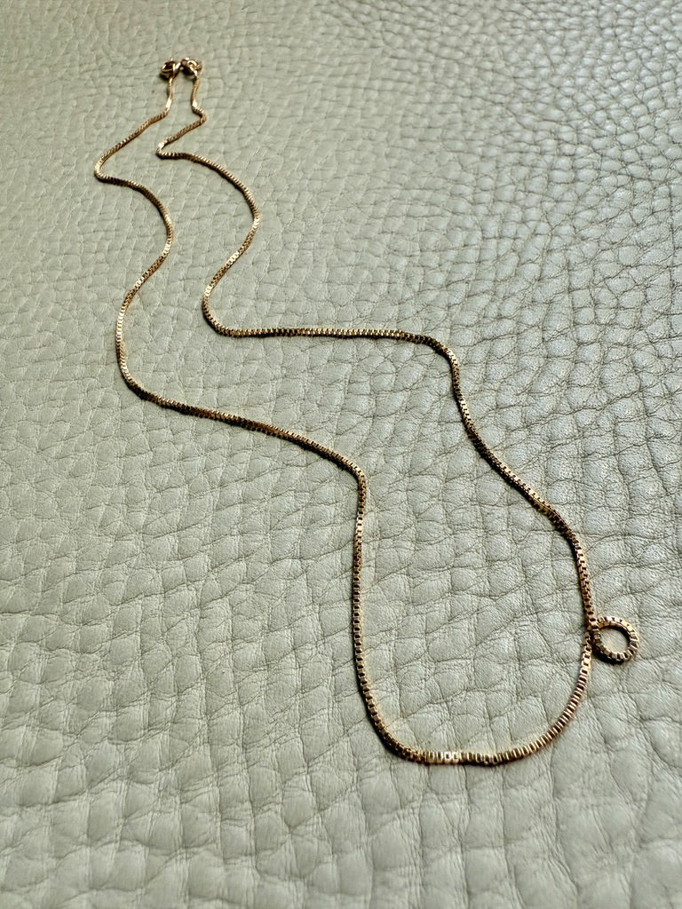 vintage Gold necklace on a textured light gray surface
