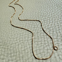 vintage Gold necklace on a textured light gray surface