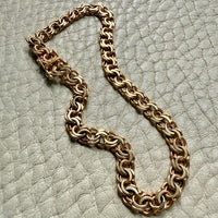 18k Gold chain bracelet on a textured light gray surface
