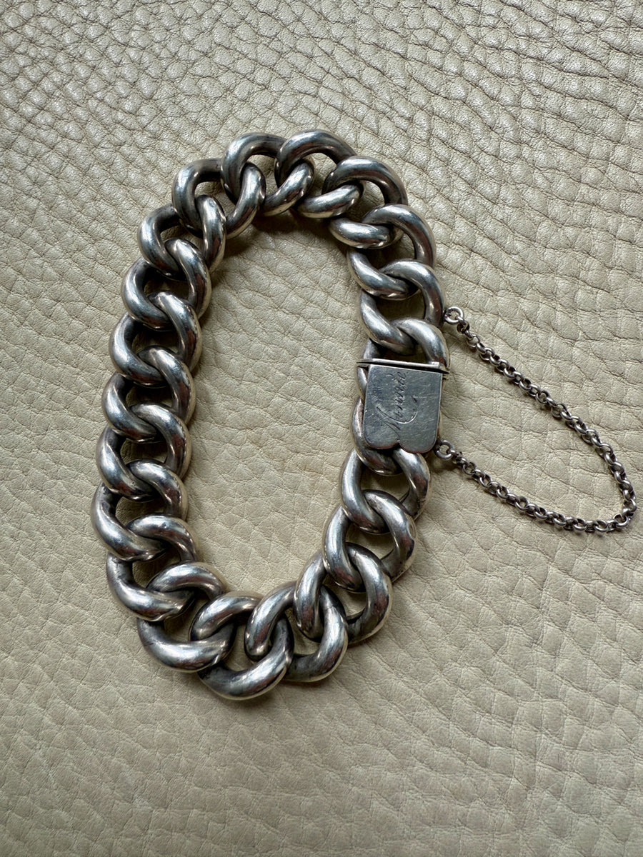 Silver chain bracelet on a textured beige surface