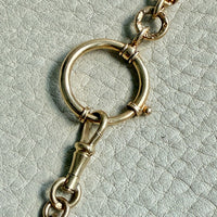 antique 18k Gold chain with a large bolt clasp on a textured light gray background. PenelopePenelope.com