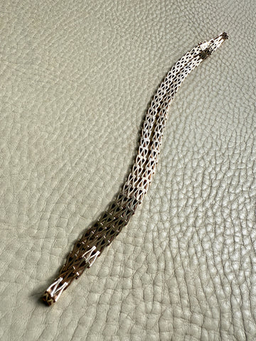 gold necklace with a pattern on a textured surface