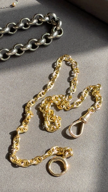 Gold and silver chain necklaces on a gray surface
