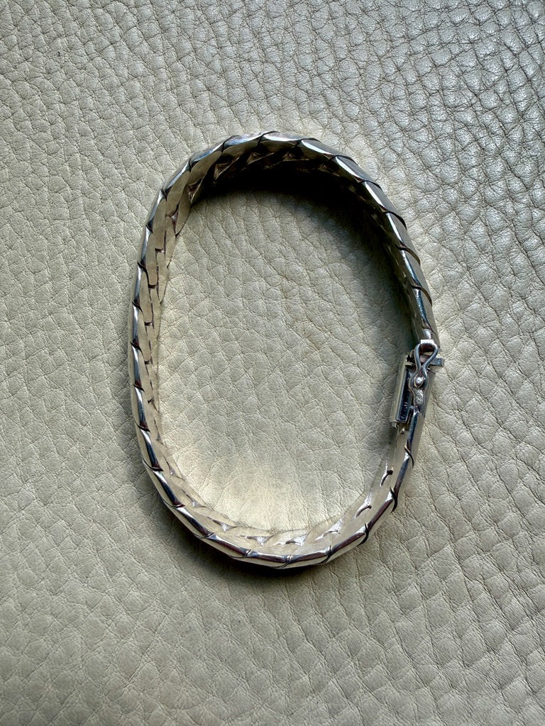 Silver bracelet on a textured beige surface