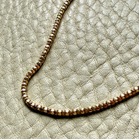 Gold chain on a textured light gray surface