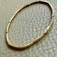 vintage 18k Gold bracelet on a textured gray surface penelopepenelope.com
