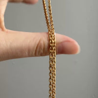vintage gold chain moving in a person's hand
