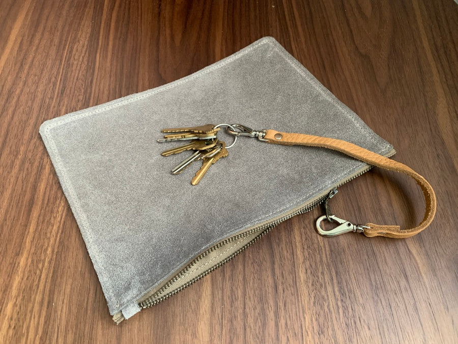 Simple leather zipper pouch to keep you organized.  Bovine suede.  Measures 10” x 7”  Metal zip with donut pull. Attach a wrist strap to zipper tab to make this into a clutch.